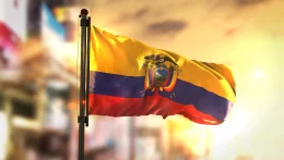 ecuador-flag-against-city-blurred-background-sunrise-backlight_1379-1763